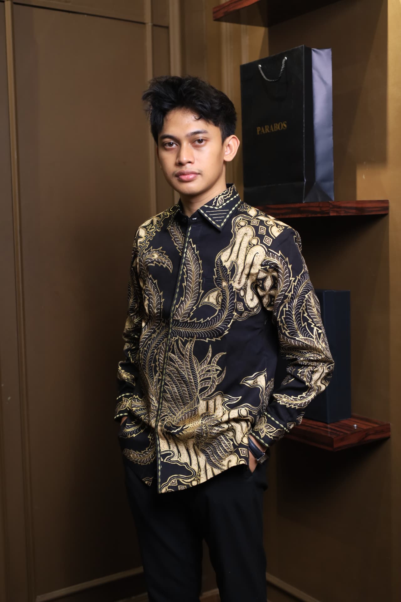 Kemeja Lar Prada — Kemeja batik tulis hitam lengan panjang bermotif lar sayap prada emas dikenakan model